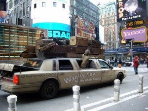 A dull gold limousine with the words "Wacky fun for the whole family!" painted across its side and some very strange gimmicky attachments.  Must be some sort of weird advertisement on wheels. Only in New York...