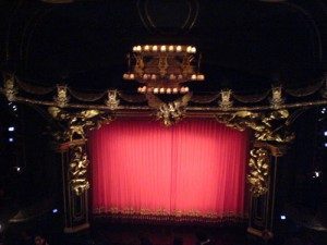 The stage at the very end, with red velvet curtains drawn shut.